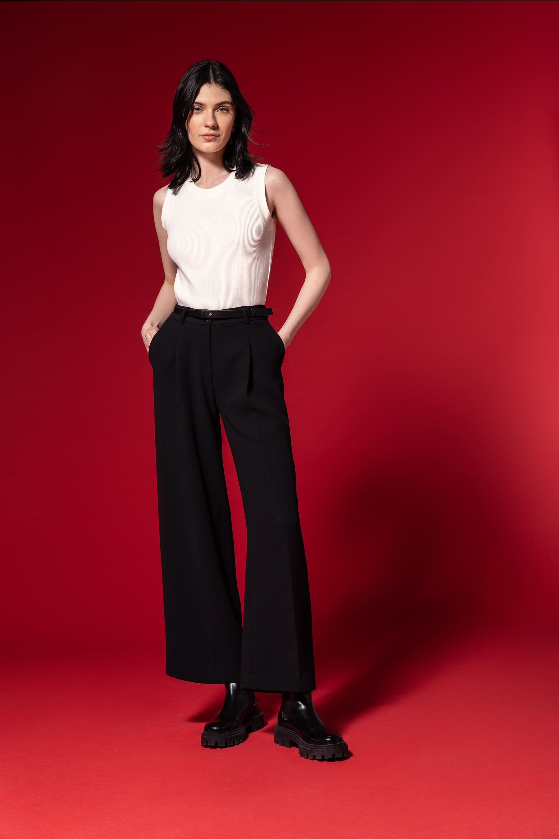 Look discreto de mujer de pantalones negros y top blanco