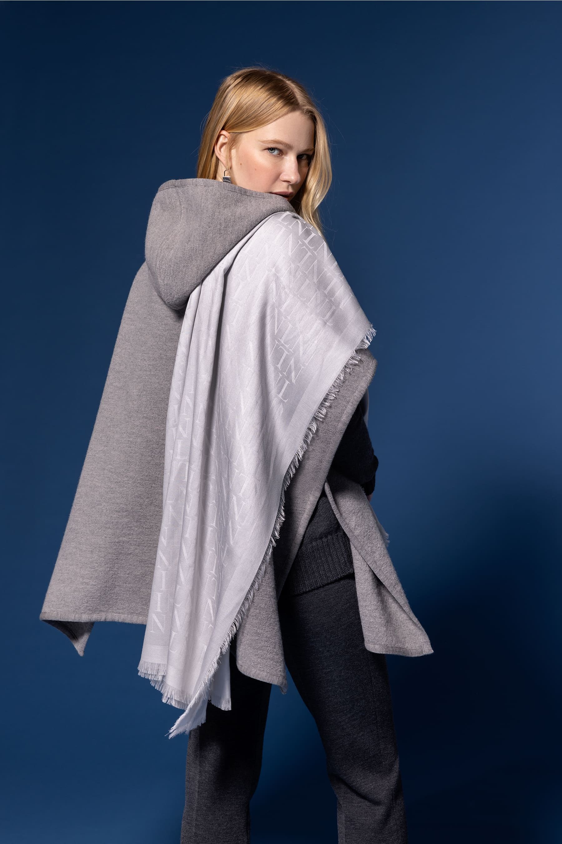 Outfit con capa, pantalones y foulard de distintas tonalidades de gris