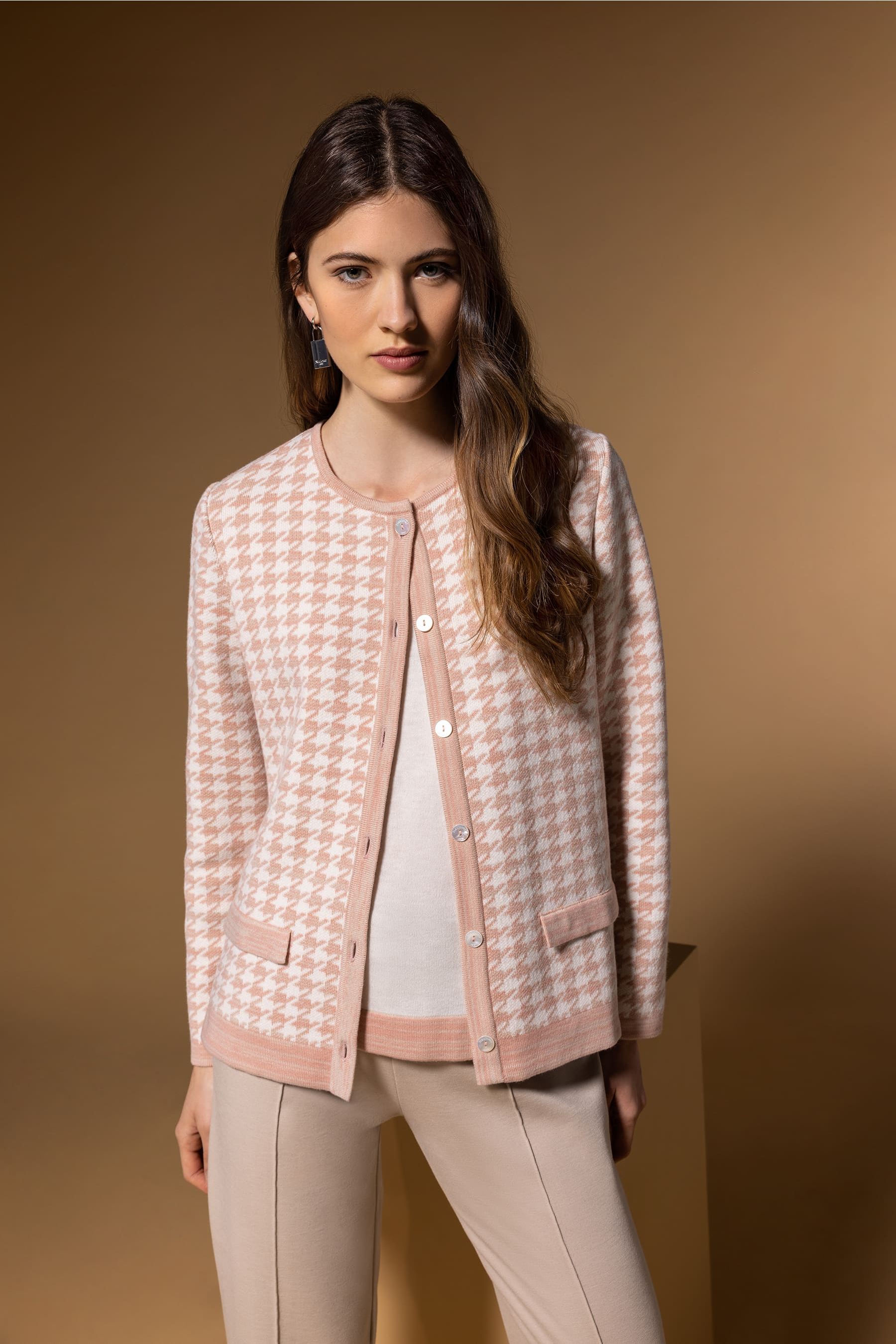 Mujer que lleva un conjunto a juego de jersey y cárdigan rosa y blanco