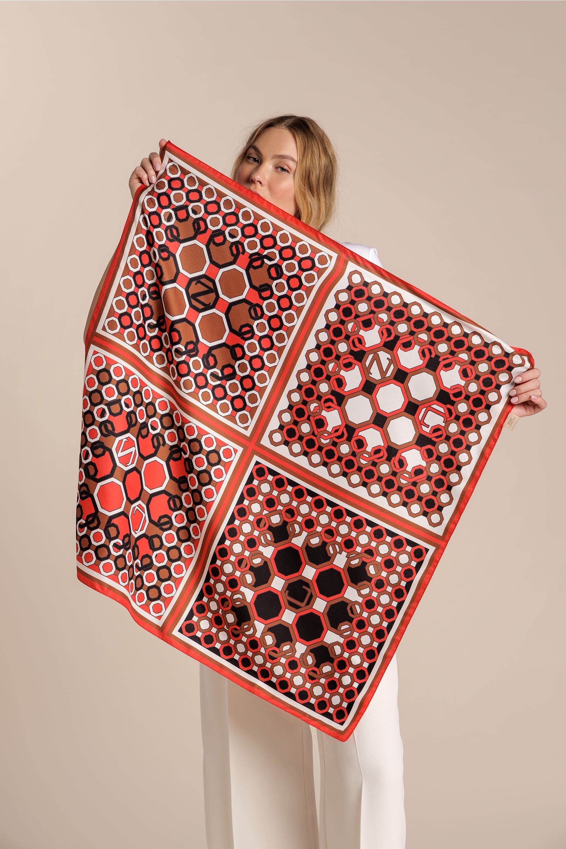 Foulard con estampado geométrico combinando los colores blanco, rojo, negro y marrón con el logo de Naulover